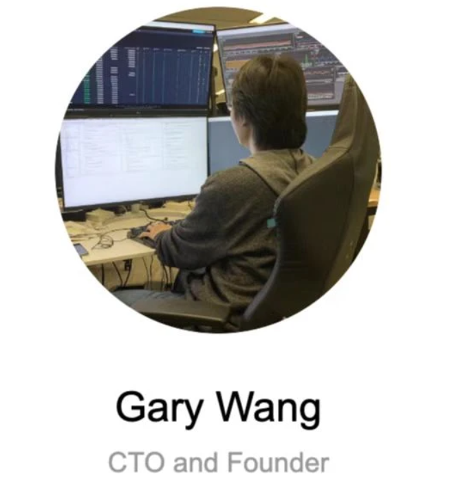 A person sitting at a desk with multiple computer screensDescription automatically generated